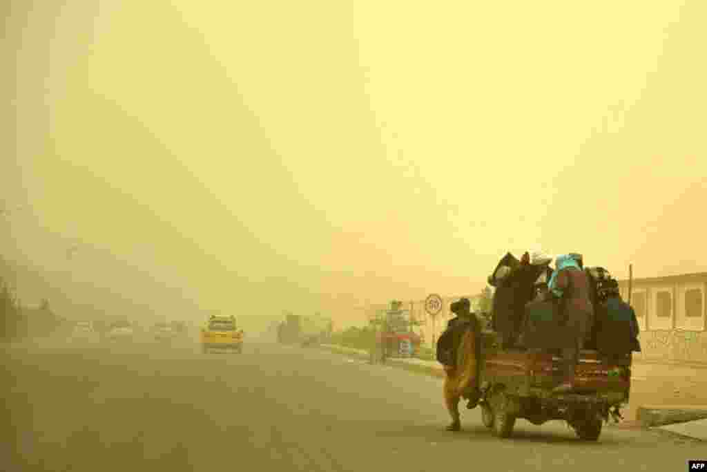 Commuters travel in a vehicle during a dust storm in Kandahar, Afghanistan.