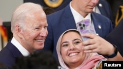 Presiden AS Joe Biden melakukan selfie bersama salah satu hadirin di acara perayaan Idulfitri di Gedung Putih, 2 Mei 2022. Foto: Reuters