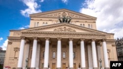 FILE - A man walks in front of the Bolshoi Theatre in Moscow on May 15, 2020, during a strict lockdown in Russia to stop the spread of the novel coronavirus COVID-19.