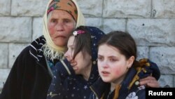 Residents react as they are evacuated from a village retaken by Ukrainian forces, next to a frontline, near Kharkiv, Ukraine, May 2, 2022. 