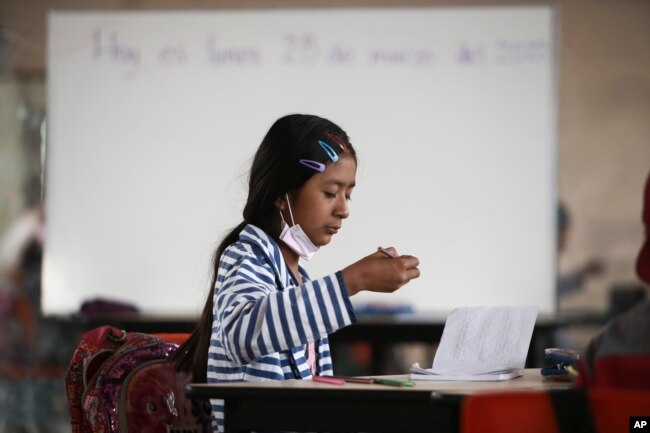 A student focuses on her lesson at Casa Kolping in Ciudad Juarez, Mexico, on Monday, March 28, 2022. (AP Photo/Christian Chavez)