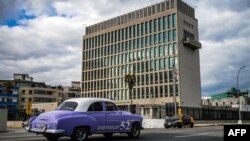 An old American car passes by the US embassy in Havana, Cuba on May 3, 2022.