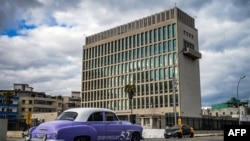 An old American car passes by the US embassy in Havana, Cuba on May 3, 2022.