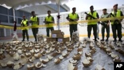 ARCHIVO - Agentes de la Guardia Nacional venezolana muestran cocos rotos que contenían cocaína en Caracas, jueves 13 de noviembre de 2008. 
