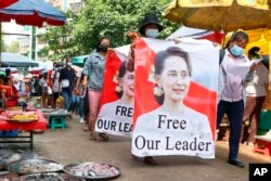 រូប​ឯកសារ៖ បាតុករមីយ៉ាន់ម៉ា​ដើរ​កាត់​ទី​ផ្សារ​មួយ​កន្លែង​ដោយ​កាន់​បដា​ទាមទារ​ឱ្យ​មាន​ការ​ដោះលែង​មេដឹកនាំ​ដែល​ត្រូវ​បាន​ដក​ចេញ​ពី​តំណែង​គឺ​លោកស្រី Aung San Suu Kyi នៅ​ក្នុង​បាតុកម្ម​មួយ​នៅ​ទី​ក្រុង​ Yangon ​កាល​ពី​ថ្ងៃ​ទី​២៨ ខែ​មេសា ឆ្នាំ​២០២១។