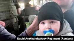 1일 우크라이나 마리우폴 시내 아조우스탈 제철소 민간인 대피 작업을 통해 보호자와 함께 버스에 탑승한 아기가 카메라를 바라보고 있다. ('아조우 연대' David Arakhamia 촬영 영상 캡쳐)