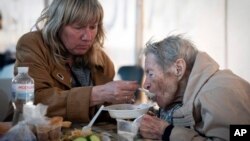 People have a meal after arriving from the Ukrainian city of Mariupol at a center for displaced people in Zaporizhzhia, Ukraine, May 3, 2022. 