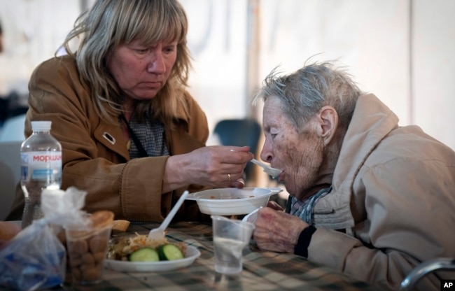 Un anciano ucraniano evacuado desde Mariúpol es alimentado en un centro para personas desplazadas en Zaporizhzhia, Ucrania, el 3 de mayo de 2022.