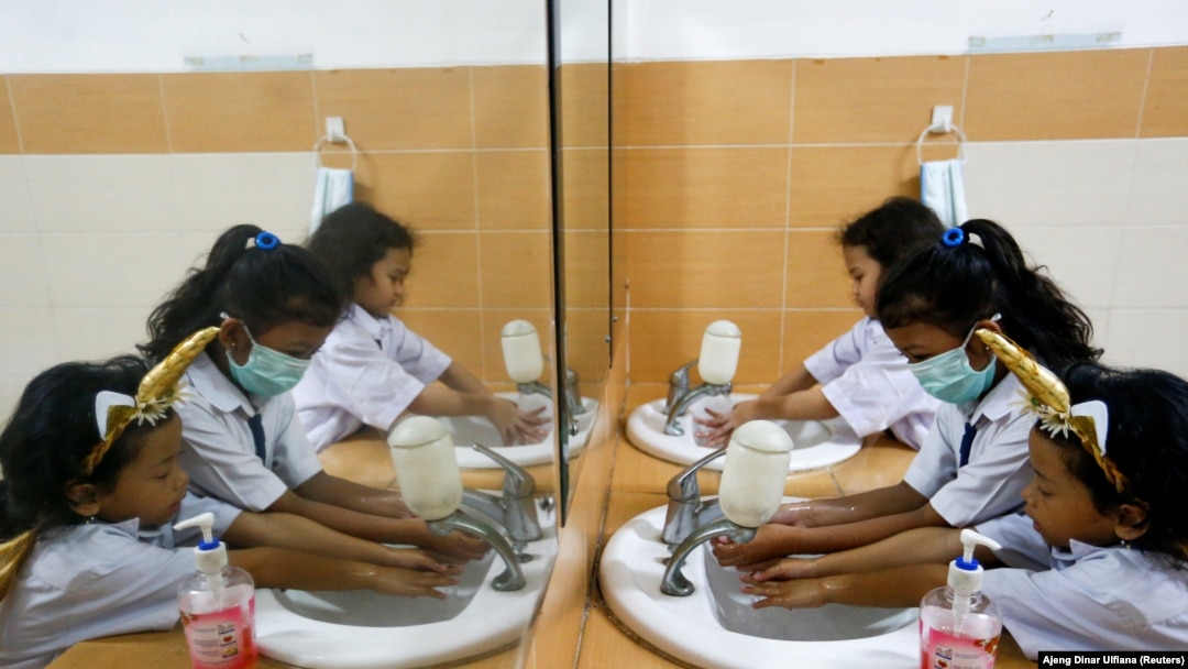 Siswa SD yang memakai masker sedang mencuci tangan usai sekolah, di Jakarta, 9 Maret 2020. (Foto: REUTERS/Ajeng Dinar Ulfiana)