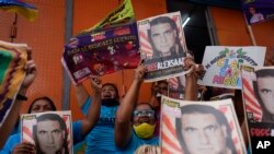 Manifestantes sostienen carteles con la imagen de Alex Saab, quien ha sido extraditado a Estados Unidos, durante una manifestación para exigir su liberación, en el barrio de Petare en Caracas, Venezuela, el lunes 4 de abril de 2022.