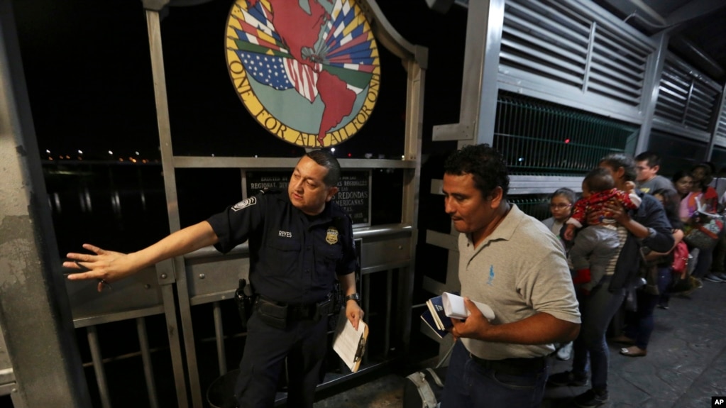 En esta fotografía del 17 de septiembre de 2019, un agente fronterizo estadounidense le da indicaciones a una familia de migrantes nicaragüenses que desean obtener asilo en Estados Unidos, en la frontera entre Laredo, Texas, y Nuevo Laredo, México.