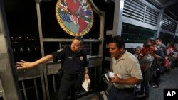 ARCHIVO - Un agente fronterizo estadounidense le da indicaciones a una familia de migrantes nicaragüenses que desean obtener asilo en EEUU, en la frontera entre Laredo, Texas, y Nuevo Laredo, México. 