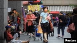 People wearing masks to protect against the coronavirus shop at a market in Keelung, Taiwan, April 28, 2022.