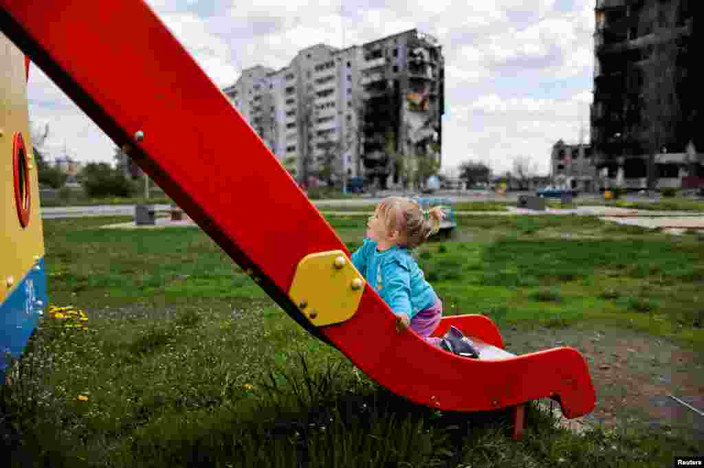 Nina Stefuryak, 2, plays at the playground in front of a building destroyed by shelling&nbsp;in Borodianka, Kyiv region, Ukraine, amid the Russian invasion of Ukraine, May 2, 2022.