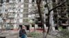 A Mariupol, Ukraine, resident sits on a bench near an apartment building heavily damaged during Ukraine-Russia conflict, May 2, 2022.