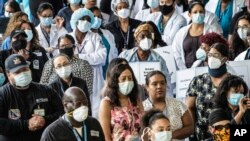 FILE - Health care workers at Brooklyn's Kings County Hospital show solidarity with the Black Lives Matter movement, June 4, 2020, in New York during the coronavirus pandemic. 