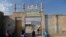 FILE - This picture taken on November 7, 2021 shows a student walking through the entrance of the Darul Uloom Hakimia madrassa where the Taliban Supreme Leader Hibatullah Akhundzada reportedly appeared, in Kandahar province.