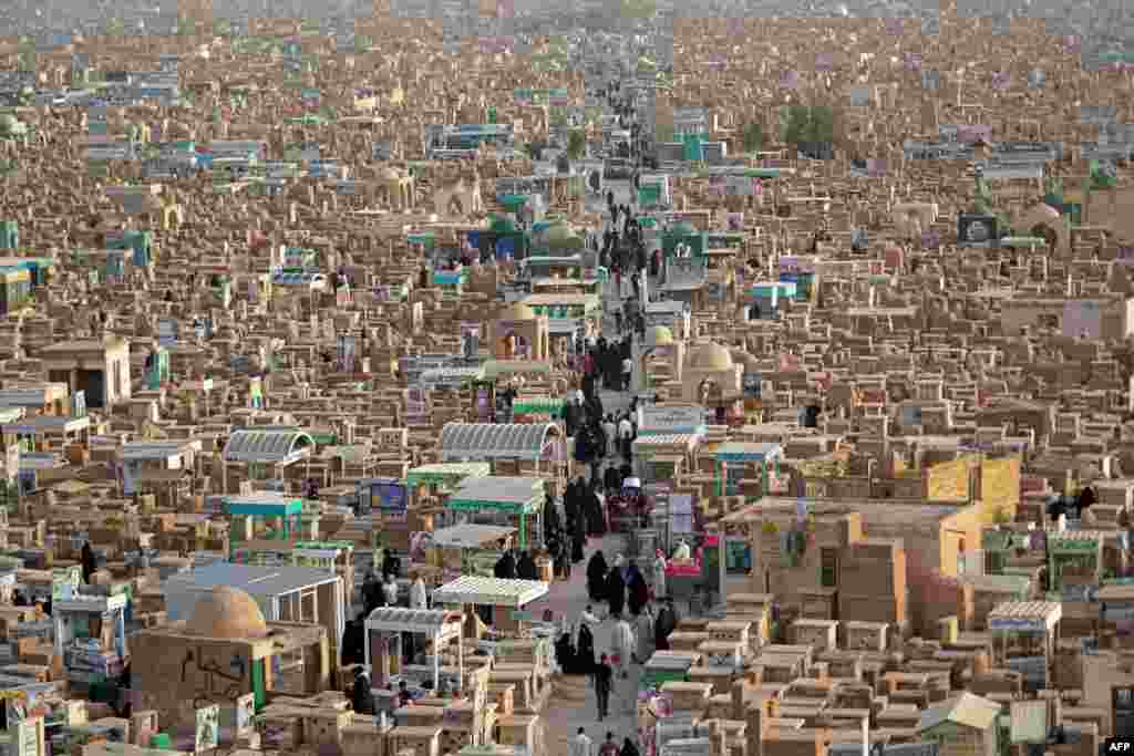 Muslims visit the graves of their family members at the Wadi al-Salam (Valley of Peace) cemetery in Iraq&#39;s holy city of Najaf during Eid al-Fitr holiday, which marks the end of the holy fasting month of Ramadan, May 3, 2022.