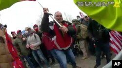 FILE - This still frame from Metropolitan Police Department body worn camera video shows Thomas Webster, in red jacket, at a barricade line at on the west front of the U.S. Capitol on Jan. 6, 2021, in Washington. 