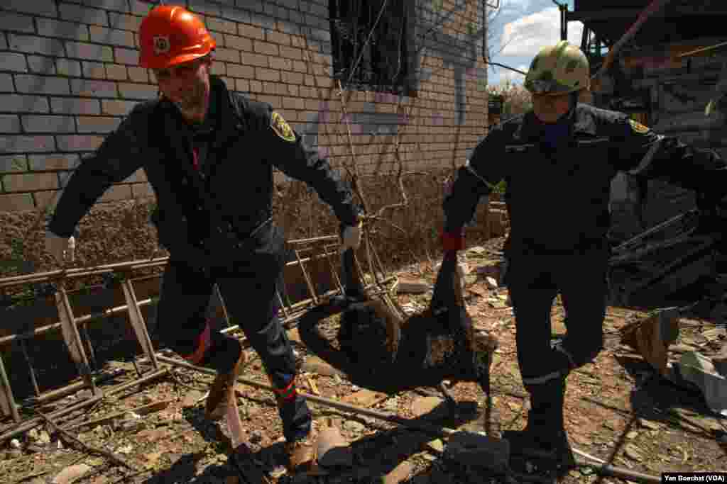 Rescue workers collect a dog killed in a Russian missile attack on a residential neighborhood in Zaporizhzhya, Ukraine. Three people were injured in the strike on April 28, 2022.