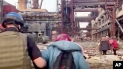 This frame taken from an undated video provided Sunday, May 1, 2022 by the Azov Special Forces Regiment of the Ukrainian National Guard shows people walking over debris at the Azovstal steel plant, in Mariupol, eastern Ukraine. (Azov Special Forces Regiment Handout via AP)