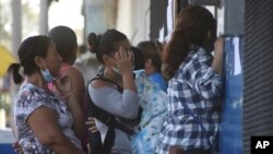 Familiares de personas arrestadas por la policía esperan afuera de la prisión temporal El Penalito pidiendo información sobre sus seres queridos en Ciudad Delgado, El Salvador, el miércoles 6 de abril de 2022.