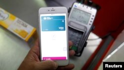 FILE - A shopper uses the mobile payment service Apple Pay at a supermarket, in Ronda, southern Spain, Oct. 9, 2020. 