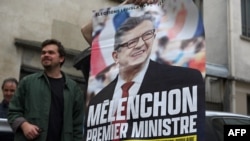 Militants of French leftist movement La France Insoumise (LFI) display a campaign poster reading in French "Melenchon, Prime Minister" outside LFI's headquarters in Paris on May 3, 2022, where discussions are underway on a broad alliance between the four 