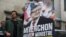 Militants of French leftist movement La France Insoumise (LFI) display a campaign poster reading in French "Melenchon, Prime Minister" outside LFI's headquarters in Paris on May 3, 2022.
