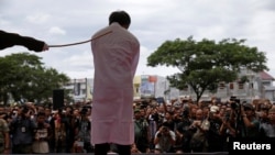 Seorang pria di Aceh menjalani hukuman cambuk karena kedapatan melakukan hubungan sesama jenis. Hukuman dilakukan di depan publik Banda Aceh, pada 23 Mei 2017. (Foto: Reuters/Beawiharta)
