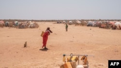 Une femme se tient près de robinets d'eau hors service dans un camp de personnes déplacées à Gode, en Éthiopie, le 6 avril 2022.