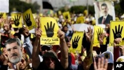 Protesters hold placards with the symbol of Rabaah al-Adawiya mosque, where supporters of Egypt's ousted President Morsi held a sit-in that was violently dispersed, Cairo, Sept. 13, 2013.