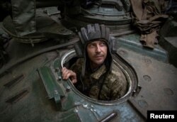 A Ukrainian serviceman looks out of an armoured recovery military vehicle in Donetsk region