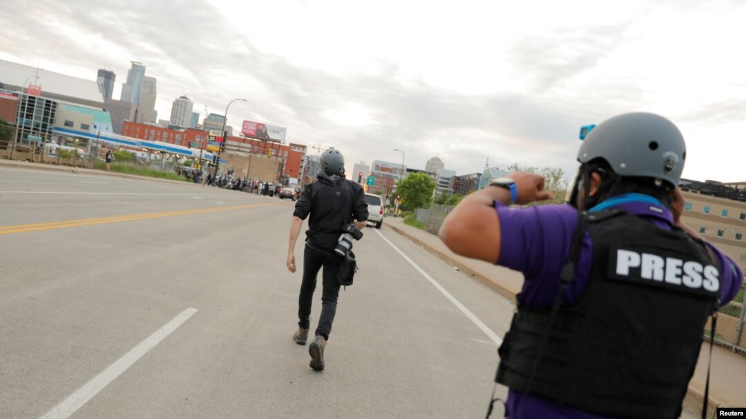 FILE - AP photojournalists John Minchillo and Julio Cortez cover continued demonstrations in reaction to the death in Minneapolis police custody of George Floyd, in Minneapolis, Minn., May 31, 2020.