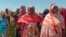 FILE - Sudanese refugees displaced by the conflict in Sudan gather to receive food staples from aid agencies at the Metche Camp in eastern Chad on March 5, 2024.