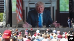 ARCHIVO - Seguidores del expresidente Donald Trump escuchan un mensaje suyo durante un evento del movimiento Make America Great Again, en Wisconsin, en junio de 2021.