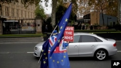 Anti-Brexit supporter Steve Bray from south Wales runs after a car carrying former UK Independence Party leader Nigel Farage outside the Houses of Parliament in London, Nov. 15, 2018. 