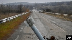 A tail of a rocket sticks out of the ground near the recently recaptured village of Zakitne, Ukraine, Nov. 9, 2022. 