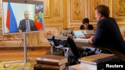 French President Emmanuel Macron talks with Russian President Vladimir Putin during a video conference at the Elysee Palace in Paris, France, June 26, 2020.