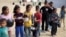 FILE —Displaced Palestinian children wait to receive free food at a tent camp, amid food shortages, in Rafah in the southern Gaza Strip, February 27, 2024.