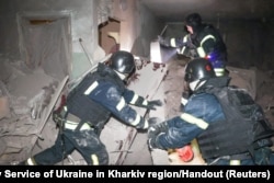 Rescuers work inside of an apartment building which was hit by a Russian air strike in Kharkiv, Ukraine, in this handout picture released on Oct. 28, 2024.