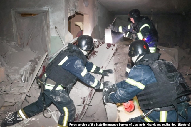 Rescuers work inside of an apartment building which was hit by a Russian air strike in Kharkiv, Ukraine, in this handout picture released on Oct. 28, 2024.