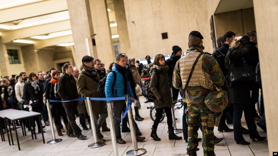 Binh sĩ Bỉ canh gác trong lúc hành khách xếp hàng để kiểm tra túi xách tại các nhà ga ở trung tâm Brussels, ngày 23/3/2016.