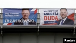 FILE - Election posters of Warsaw's Mayor Rafal Trzaskowski and Poland's President Andrzej Duda are seen during the presidential election campaign, in Piaseczno, Poland, June 22, 2020. 