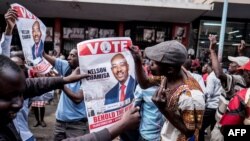 Supporters of Zimbabwean opposition MDC Alliance party leader Nelson Chamisa hold his campaign posters as they gather outside the MDC Alliance's headquarters in Harare on July 31, 2018.