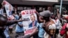 Supporters of Zimbabwean opposition MDC Alliance party leader Nelson Chamisa hold his campaign posters as they gather outside the MDC Alliance's headquarters in Harare on July 31, 2018.