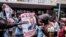 Supporters of Zimbabwean opposition MDC Alliance party leader Nelson Chamisa hold his campaign posters as they gather outside the MDC Alliance's headquarters in Harare on July 31, 2018.