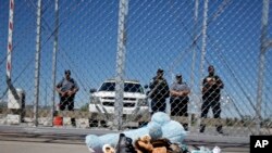 Zapatos y un oso de peluche, traídos por un grupo de alcaldes de Estados Unidos, se amontonan fuera de las instalaciones de detención de niños inmigrantes en Tornillo, Texas, cerca de la frontera con México, el jueves 21 de junio de 2018.