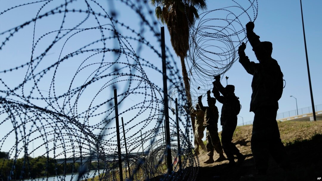 Anggota militer AS memasang beberapa lapis kawat berduri di sepanjang sungai Rio Grande dekat Jembatan Juarez-Lincoln di perbatasan AS-Meksiko, di Laredo, Texas, 16 November 2018. (Foto: dok).