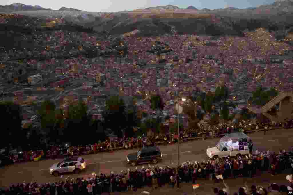 Pope Francis rides in his popemobile as he greets people lining the road from El Alto to La Paz, upon his arrival in Bolivia, July 8, 2015.